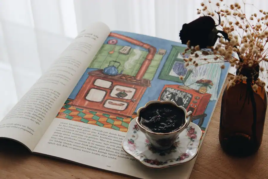 A cozy indoor setting with a cup of coffee, vintage magazine, and dried flowers, evoking a warm ambiance.